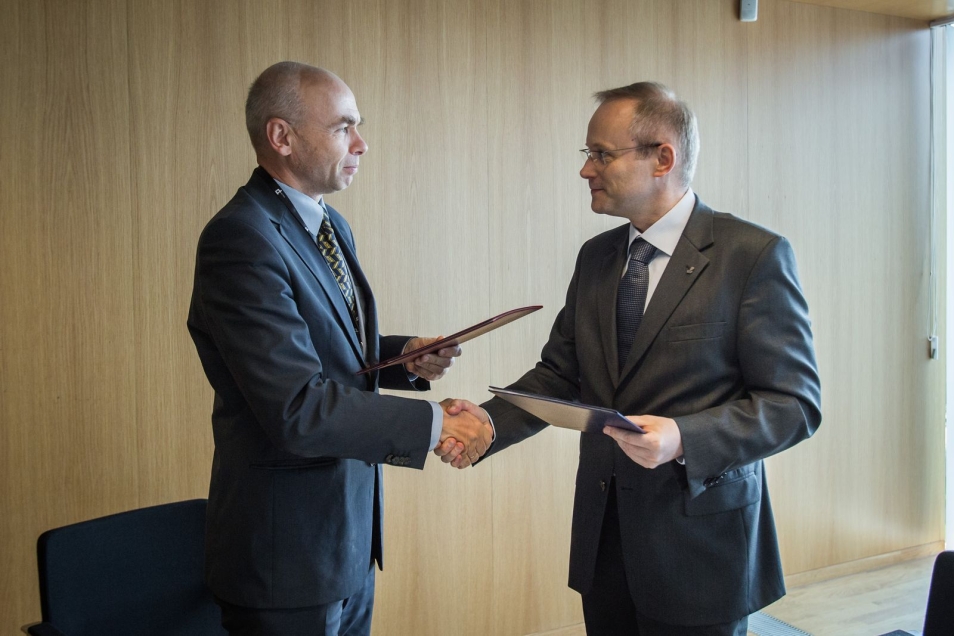 Dariusz Stola wymienia uścisk dłoni z innym mężczyzną.