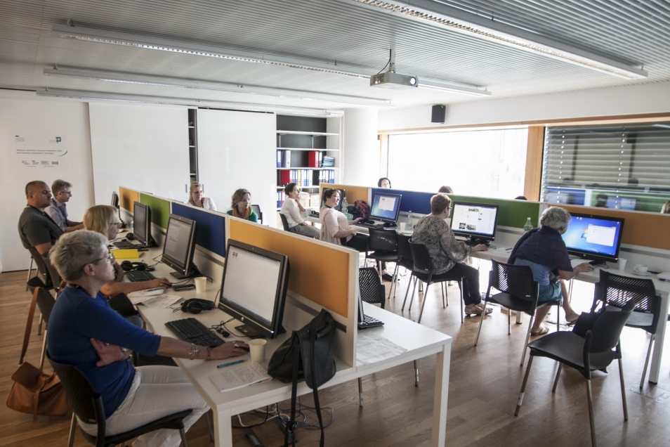 Grupa osób pracuje przy komputerach.