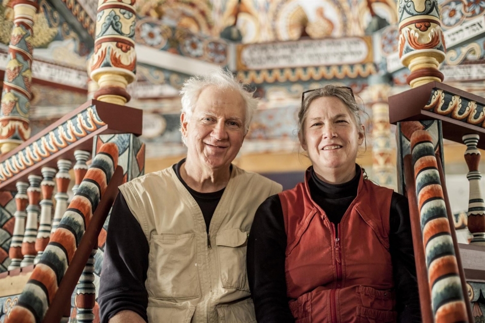 Rick and Laura Brown siedzą na schodkach zrekonstruowanej synagogi w Muzeum POLIN.