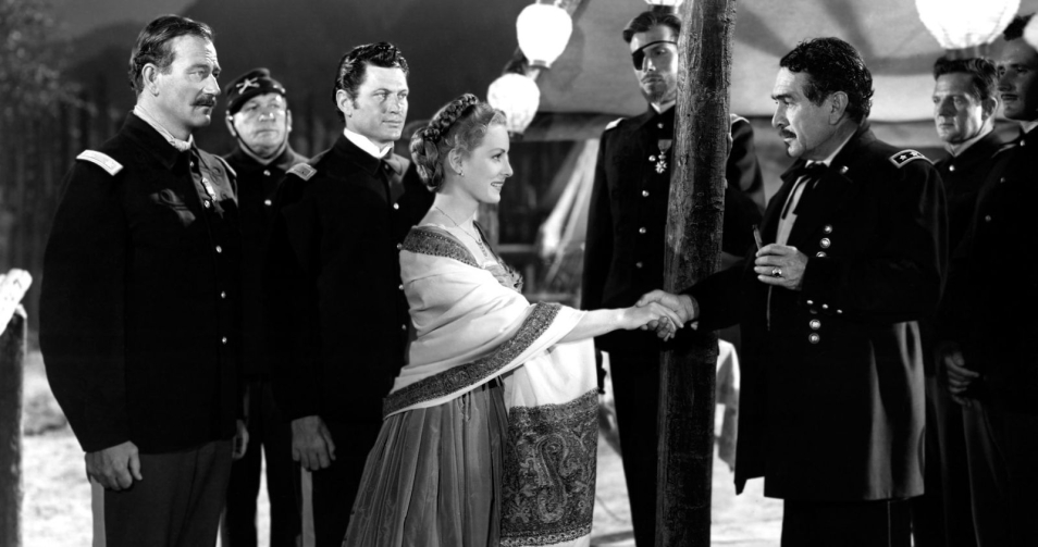 Scena z filmu "Rio Grande". Kobieta w towarzystwie mężczyzn. Podaje rękę mundurowemu.