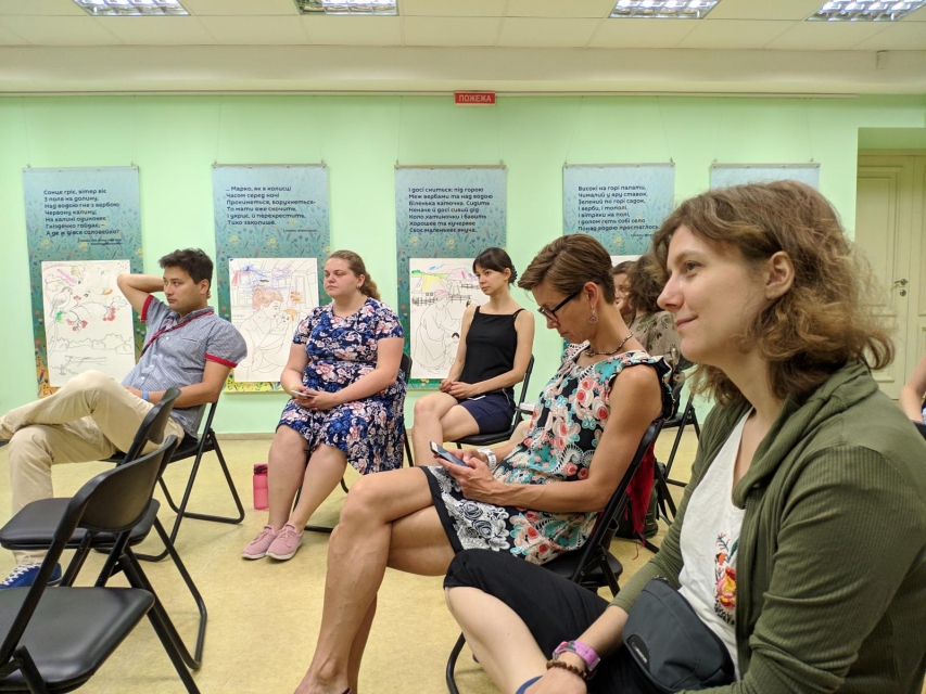 Podsumowanie projektu "EDU-NET: EAST. Przez edukację nieformalną do nowych liderów”. Na zdjęciu: uczestnicy programu podczas warsztatów, w sali edukacyjnej. Siedzą w półkolu na krzesłach.