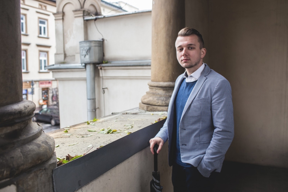 Sławomir Pastuszka. Młody mężczyzna w niebieskiej marynarce.