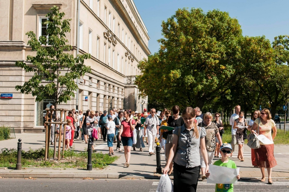 Grupa osób na przejściu dla pieszych.