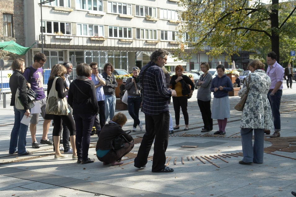 Grupa ludzi na zewnątrz podczas spaceru z przewodnikiem.