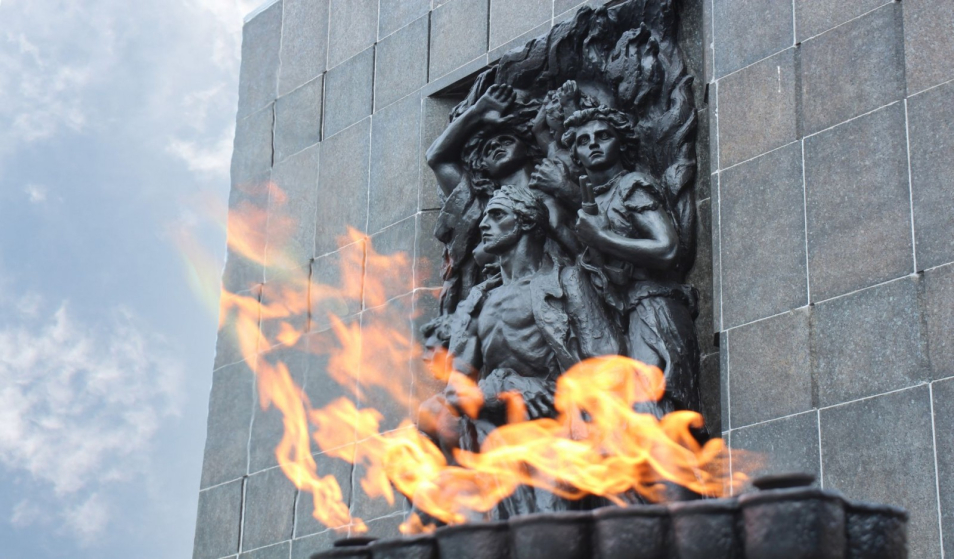 Fragment pomnika Bohaterów Getta, przed którym pali się płomień.