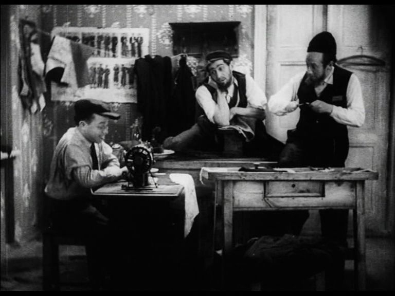 Kadr z filmu "Za grzechy". Trzech Żydów siedzi w pokoju.