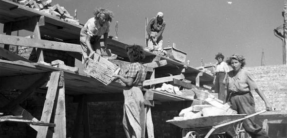 Brygada kobieca budująca blok mieszkalny. Widoczna robotnica przewożąca cegły na taczkach_fot. Siemaszko Zbyszko_NAC