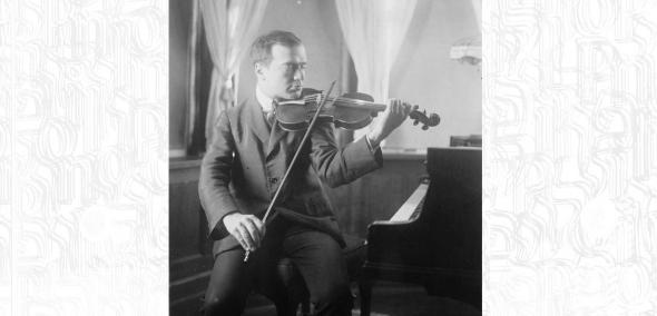 Bronisław Huberman siedzi przy fortepianie i gra na skrzypcach