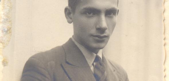 Józef Rotblat. Stara, czarno-biała fotografia przedstawia młodego mężczyznę ubranego w garnitur.