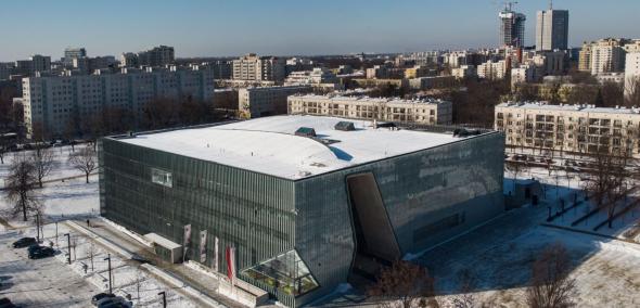 Budynek Muzeum POLIN w Warszawie, widziany z góry, w otoczeniu innych budynków osiedla Muranów. Zdjęcia zrobione zimą, dach muzeum oraz okoliczne chodniki i ulice pokryty jest śniegiem.