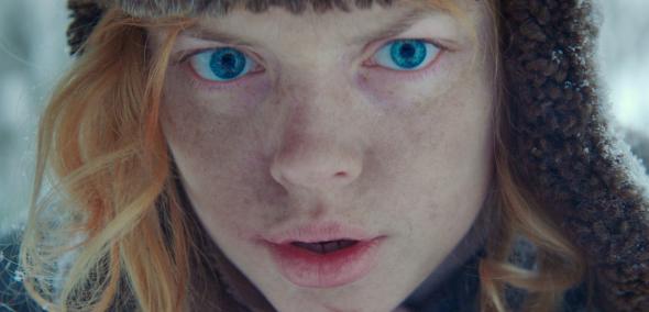 Kadr z filmu Berenshtein. Rudowłosa niebieskooka osoba w czapce.