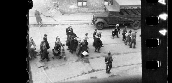 Warszawska ulica. Żydzi prowadzeni przez Niemców na Umschlagplatz. / Warsaw Street - the Jews on their way to Umschlagplatz. Around them there are German soldiers.