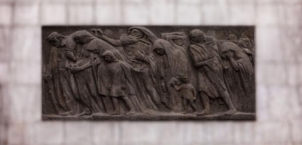 Relief na drugiej stronie pomnika Bohaterów Getta przedstawiający pochód cywilów.