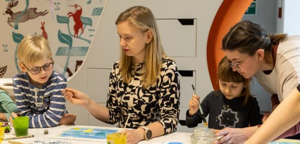 Dwie kobiety i dwoje dzieci malują ilustracje podczas warsztatów "Potwórz Sobie" w Muzeum POLIN.