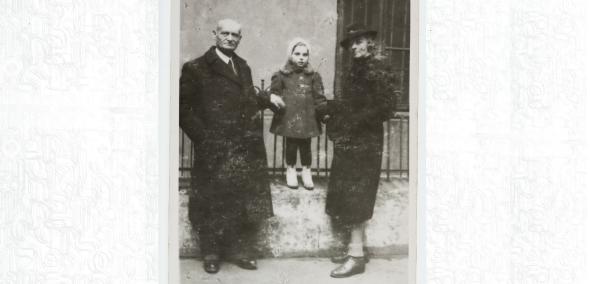 Mała Aleksandra Rozengarten (obecnie Kaniuka) stoi na ogrodzeniu. Za ręce trzymają ją matka Irena i dziadek Eliezer Rozengarten.