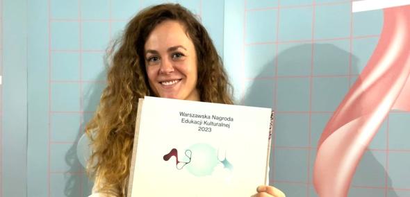 Maria Alster trzyma przed sobą dyplom za trzecie miejsce w konkursie Warszawskiej Nagrody Edukacji Kulturalnej.