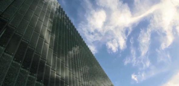 Fragment budynku Muzeum POLIN i nieba pełnego chmur.