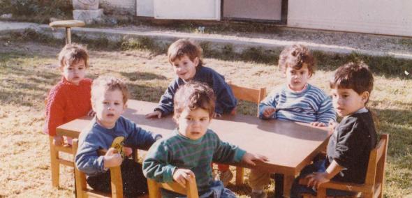 Kadr z filmu "Dzieci pokoju" - sześcioro dzieci siedzi przy stoliku na podwórku.