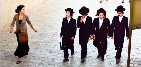 Czterech młodych Żydów i Żydówka idą po ulicy.