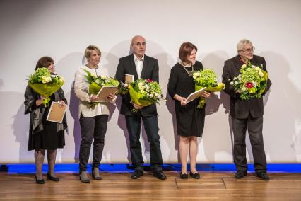 na scenie trzy kobiety i dwóch mężczyzn z kwiatami i nagrodami w dłoniach