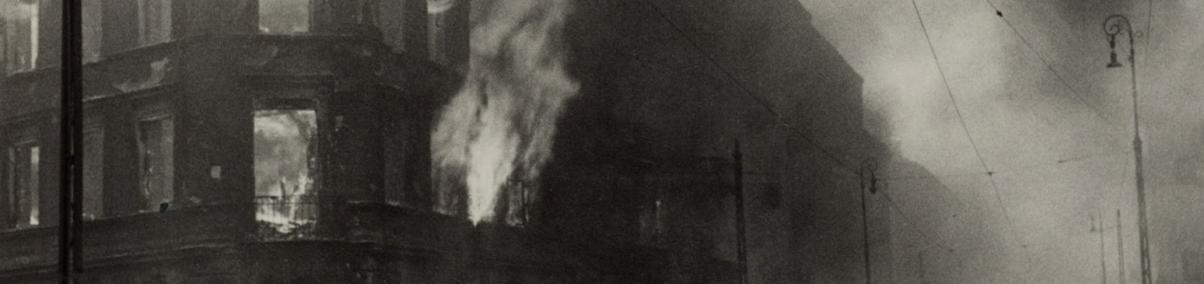 Płonący budynek w getcie warszawskim w kwietniu 1943 r. Czarno-biała fotografia.