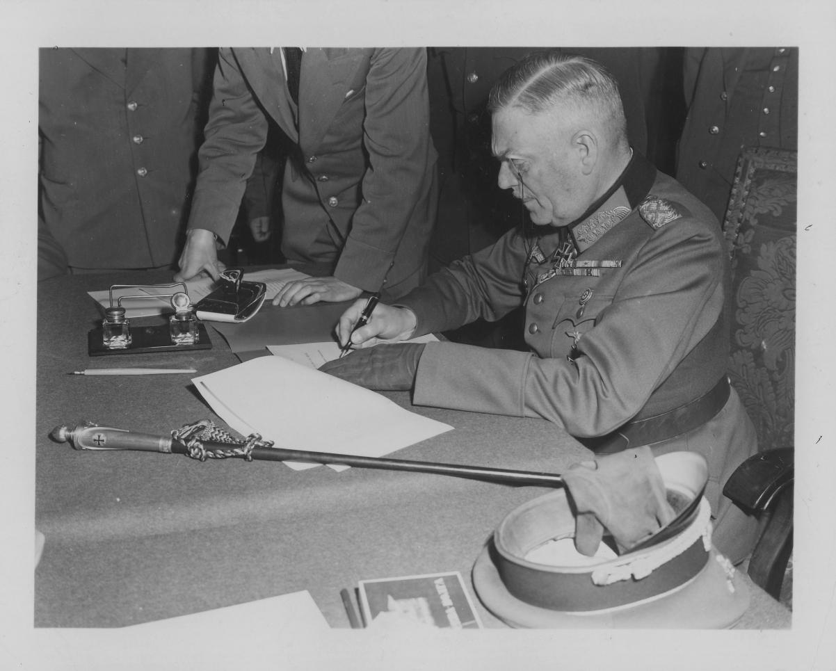 Zdjęcie archiwalne: feldmarszałek Wilhelm Keitel siedzi przy stole. Podpisuje akt kapitulacji III Rzeszy, po przegranej przez Niemcy II wojnie światowej.