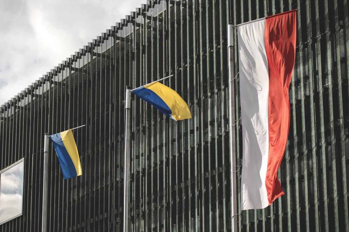 Flagi Polski i Ukrainy powiewają na wietrze, na masztach przed Muzeum POLIN