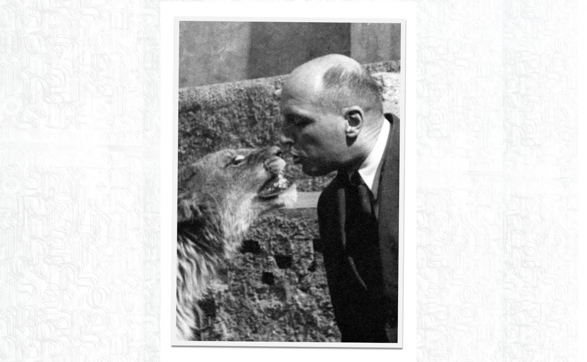 Czarno-białe zdjęcie przedstawia Jana Żabińskiego całującego lwa.