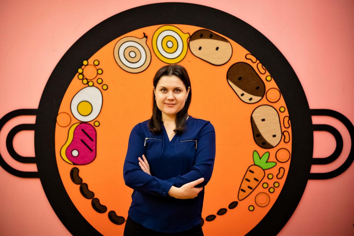 Marianna Shpak na tle miski z czulentem narysowanej na ścianie na wystawie "Od kuchni".