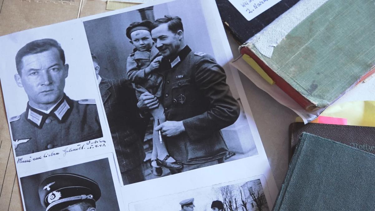 Kadr z filmu "Dobry i zły nazista". Na stole leżą rozrzucone fotografie z podobizną Wilma Rosenfelda - bohatera dokumentu.
