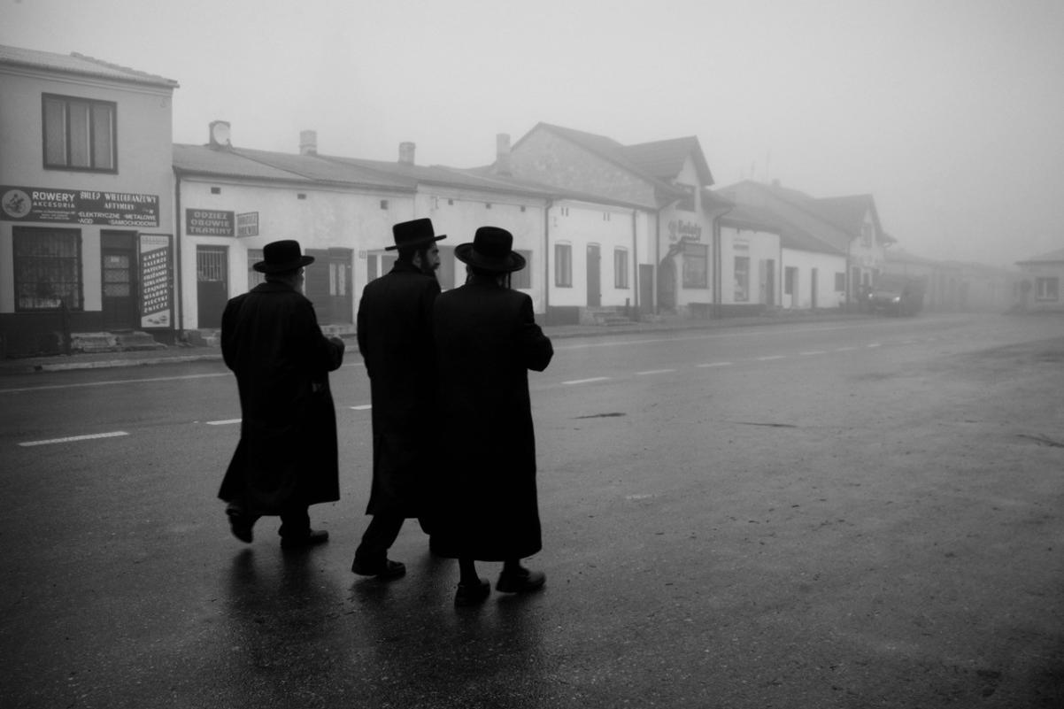 Trzej chasydzi idą po ulicy jakiegoś miasta. Fotografia Agnieszki Traczewskiej z serii Powroty.