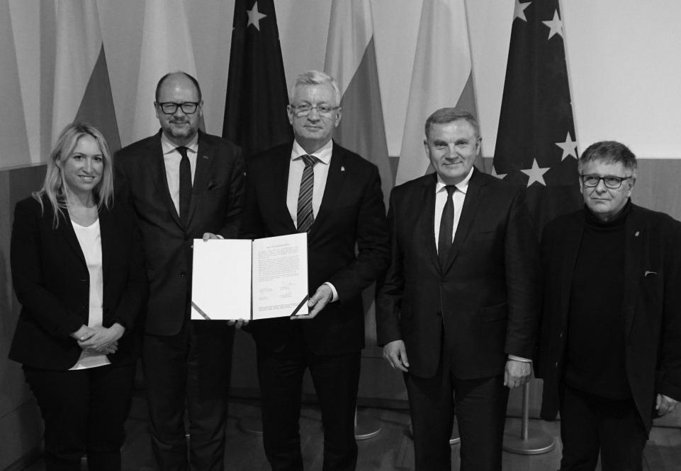 czterech prezydentów polskich miast na tle flag Polski i Unii Europejskiej prezentuje dokument