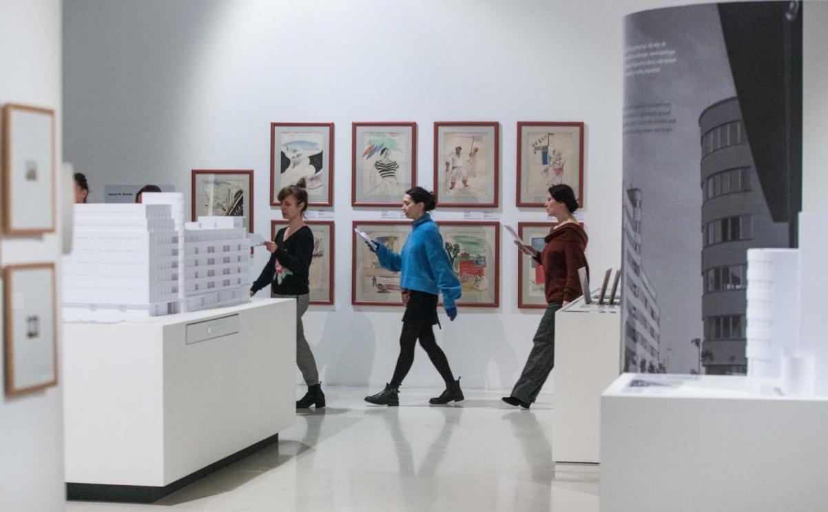 Chór POLIN na wystawie "Gdynia - Tel Awiw" - uczestnicy przedstawienia przechodzą przez przestrzeń wystawy