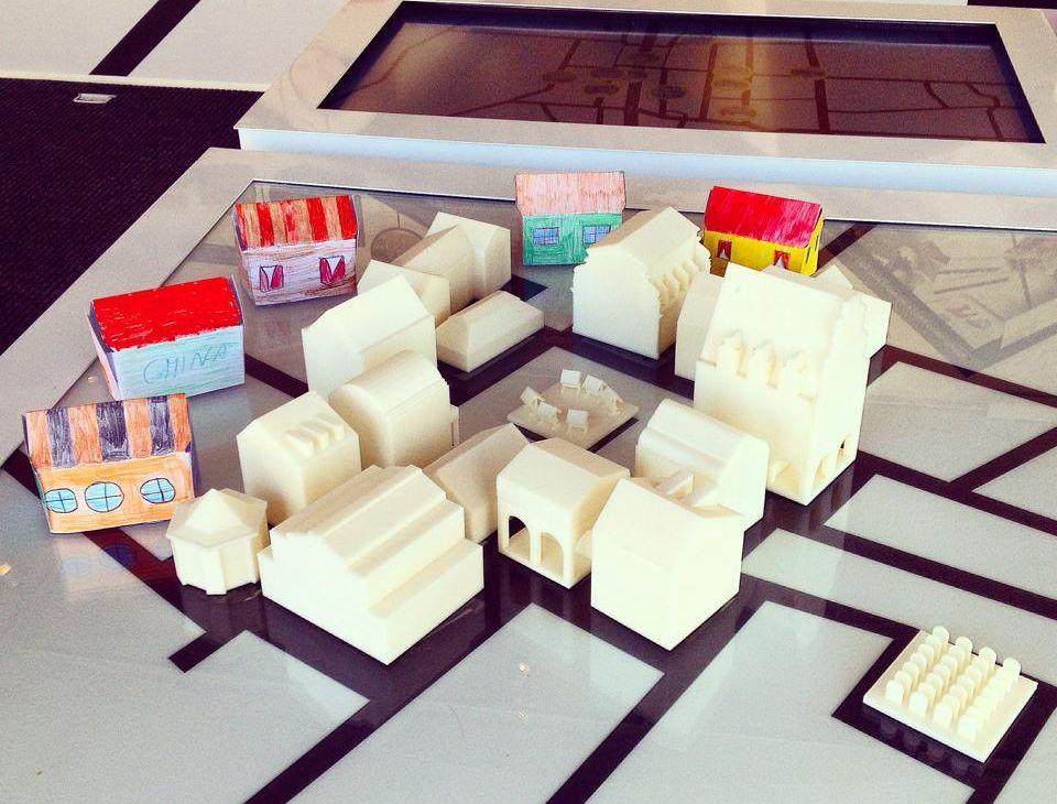 Małe modele domków na planszy.