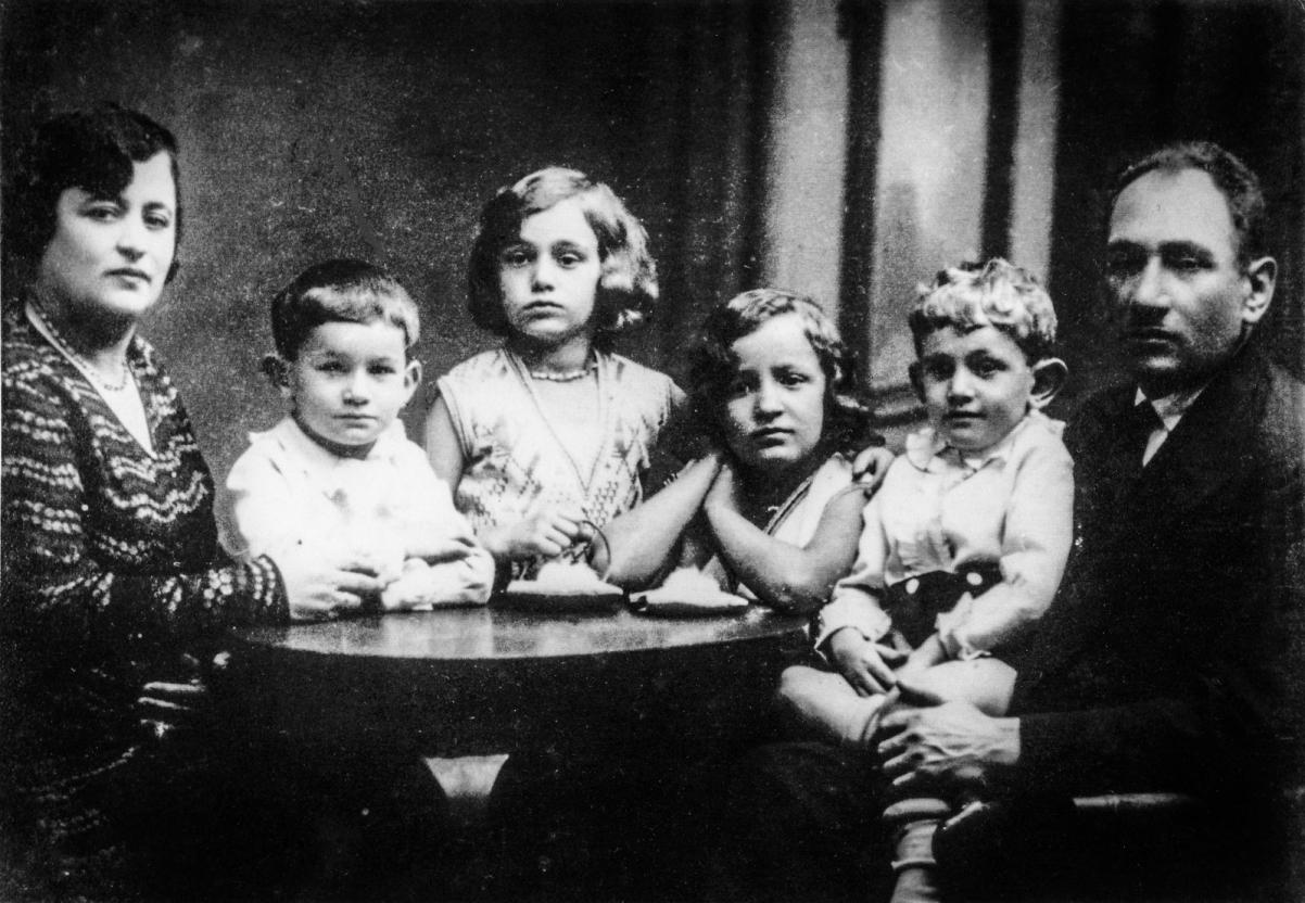 Czarno białe zdjęcie rodziny z czwórką małych dzieci przy stole