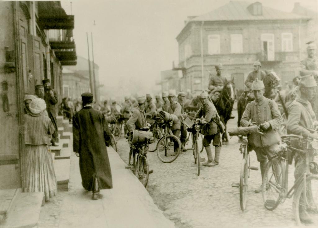 Czarno-białe zdjęcie przedstawia kilkunastu żołnierzy na rowerach.