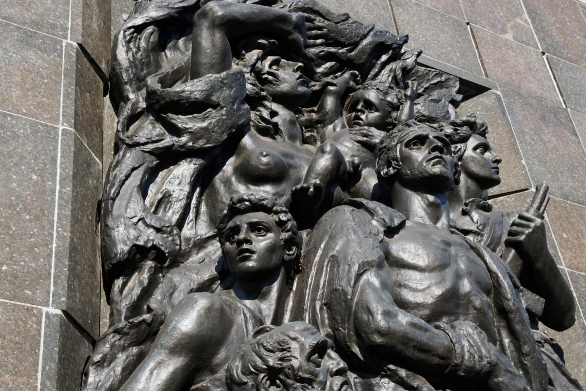 Fragment pomnika Bohaterów Getta - zbliżenie na rzeźbę, która przedstawia grupę ludzi - bojowników z getta.