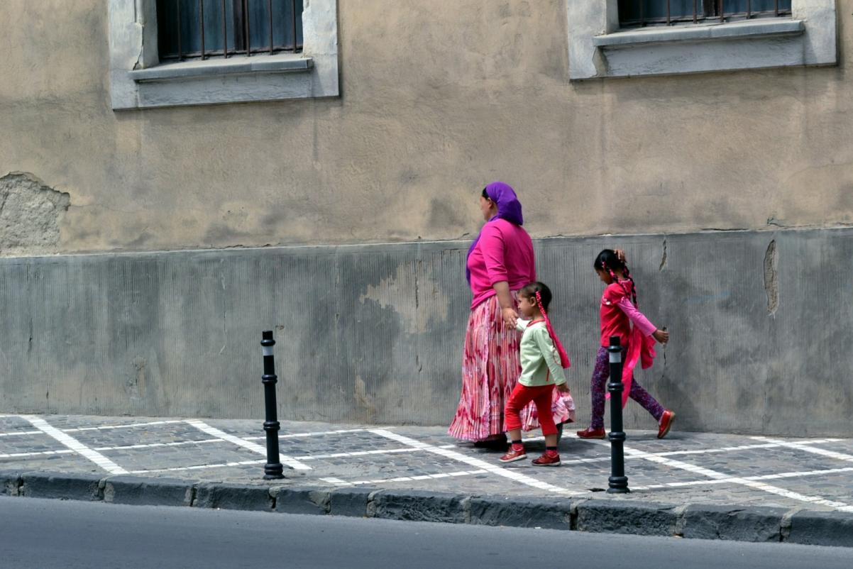 Romka z dwojgiem dzieci idzie po ulicy.