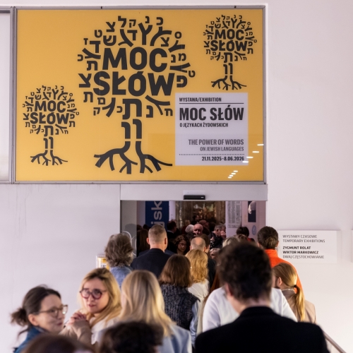 Grupa osób stoi przy wejściu na wystawę czasową "Moc słów" w Muzeum POLIN.