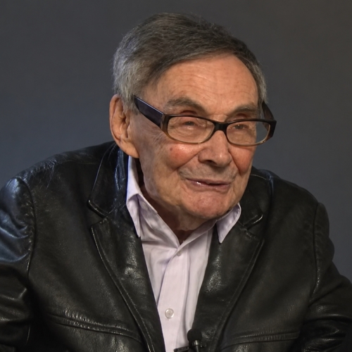 Kadr z filmu - relacji Mariana Turskiego. Marian Turski wskazuje palcem w bok.